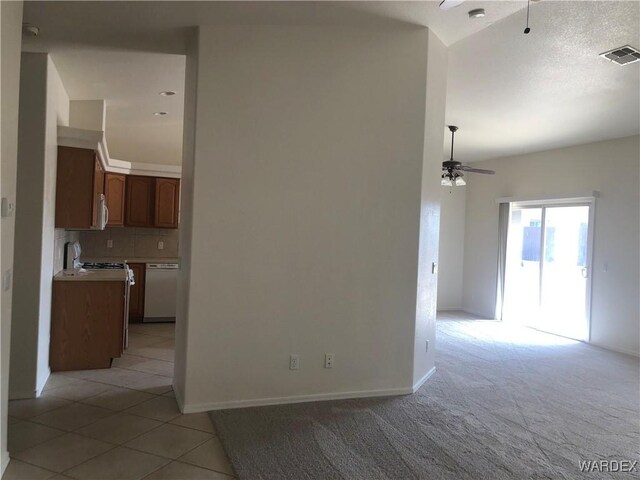 unfurnished room with light carpet, baseboards, a ceiling fan, and visible vents