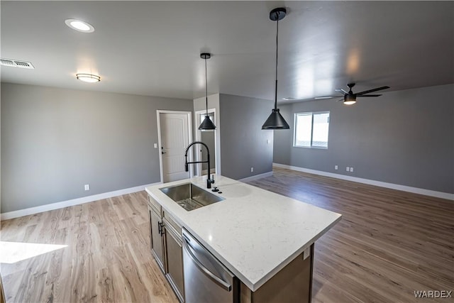 kitchen with visible vents, light wood-style flooring, stainless steel dishwasher, a sink, and baseboards