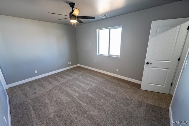 empty room with ceiling fan, carpet flooring, visible vents, and baseboards