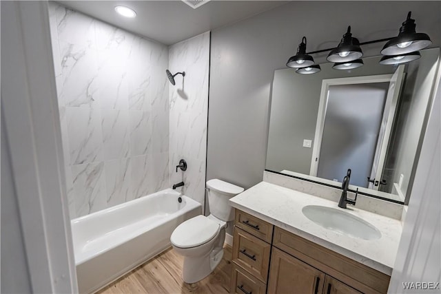 bathroom featuring toilet, shower / bath combination, wood finished floors, and vanity