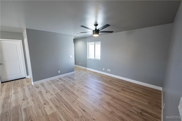 unfurnished room with ceiling fan, light wood-style flooring, and baseboards