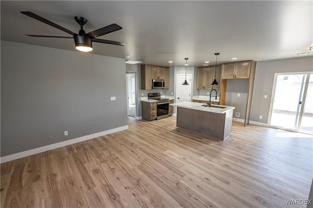 kitchen with open floor plan, appliances with stainless steel finishes, light wood-type flooring, and baseboards