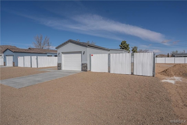 garage with fence and concrete driveway