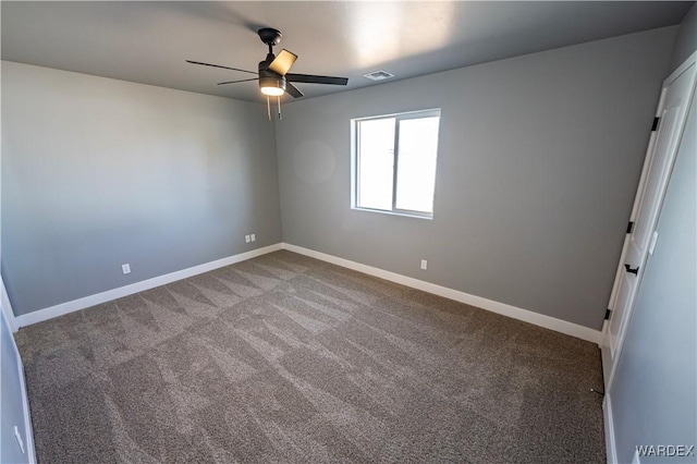 unfurnished room with carpet floors, visible vents, ceiling fan, and baseboards