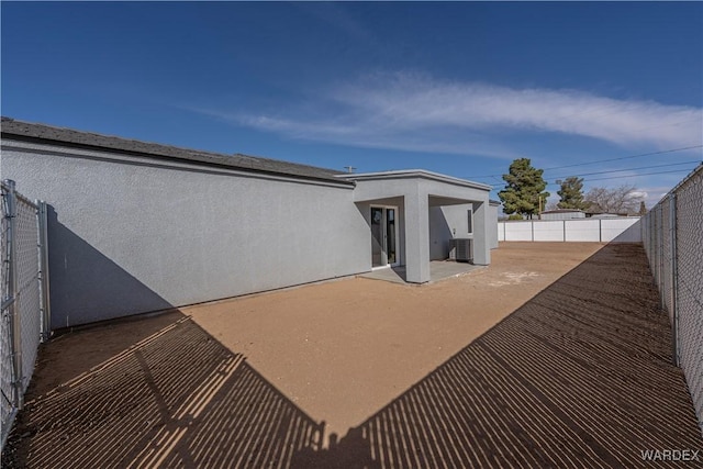 back of property featuring a patio area, a fenced backyard, central AC unit, and stucco siding