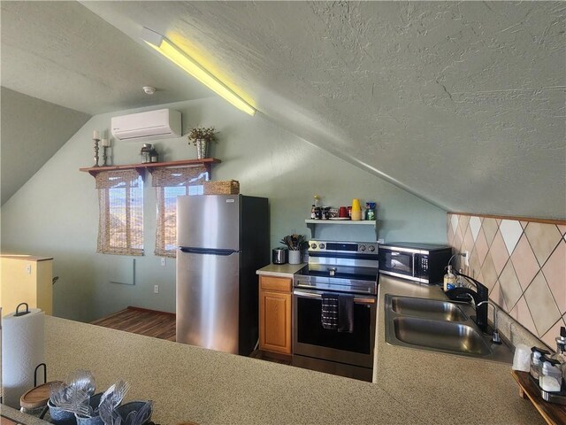 1900 W Guardian Dr, Meadview, AZ 86444 - kitchen with stainless steel appliances, vaulted ceiling, a textured ceiling, and a wall mounted air conditioner