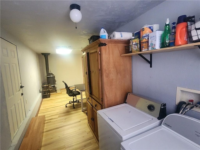 1900 W Guardian Dr, Meadview, AZ 86444 - laundry room with independent washer and dryer, light wood-type flooring, cabinet space, and a wood stove