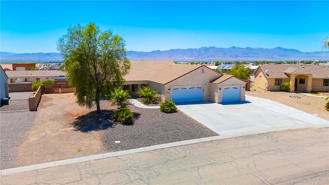 6053 S Klamath Loop, Fort Mohave, AZ 86426 - view of front of property with an attached garage, a mountain view, stucco siding, and concrete driveway
