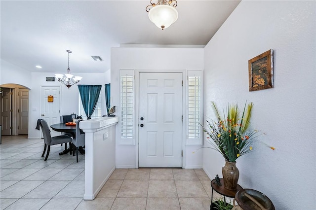 6053 S Klamath Loop, Fort Mohave, AZ 86426 - foyer with arched walkways, a chandelier, and light tile patterned floors