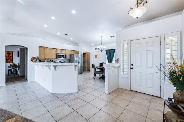 6053 S Klamath Loop, Fort Mohave, AZ 86426 - kitchen with stainless steel appliances, arched walkways, a peninsula, vaulted ceiling, and a chandelier