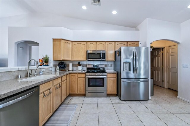 6053 S Klamath Loop, Fort Mohave, AZ 86426 - kitchen with appliances with stainless steel finishes, vaulted ceiling, arched walkways, backsplash, and light tile patterned floors