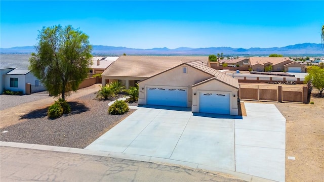 6053 S Klamath Loop, Fort Mohave, AZ 86426 - view of front of property featuring an attached garage, a mountain view, and driveway