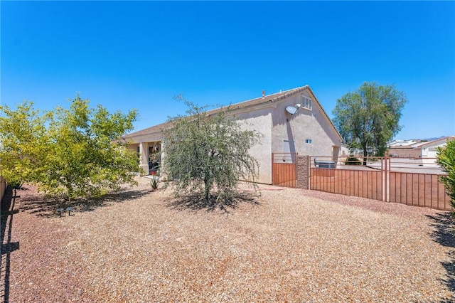 6053 S Klamath Loop, Fort Mohave, AZ 86426 - rear view of property with stucco siding and a gate