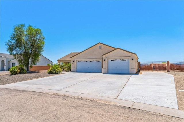 6053 S Klamath Loop, Fort Mohave, AZ 86426 - view of front of property with an attached garage, driveway, and stucco siding