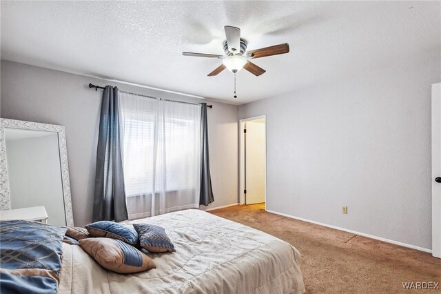 bedroom with a textured ceiling, baseboards, a ceiling fan, and light colored carpet