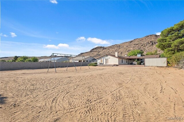 view of yard featuring fence and a mountain view