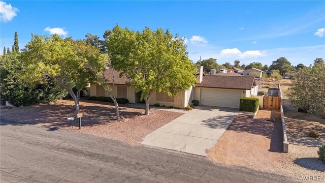 view of front of house with a garage, concrete driveway, and stucco siding