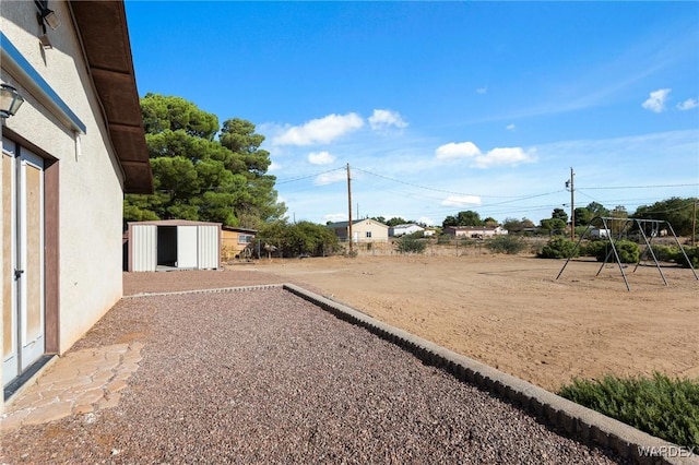 view of yard featuring a storage shed and an outbuilding