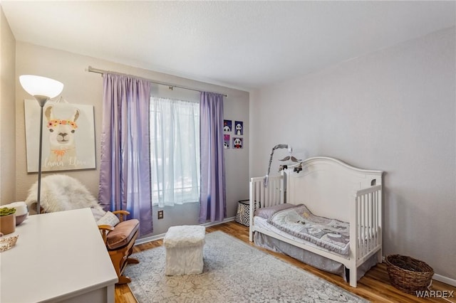 bedroom featuring baseboards and wood finished floors