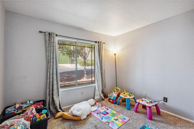 rec room with carpet and baseboards