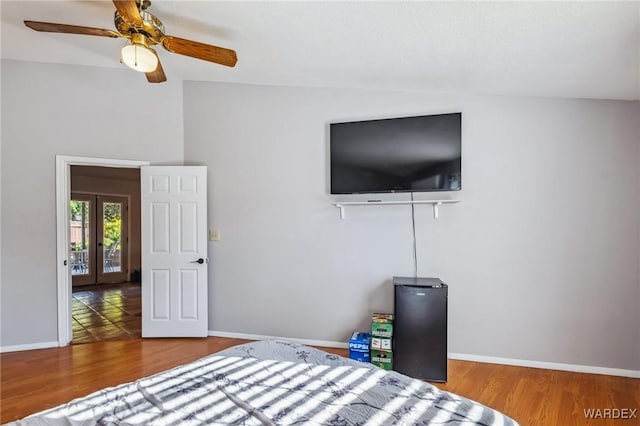 bedroom featuring lofted ceiling, ceiling fan, wood finished floors, and baseboards