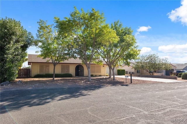 ranch-style home with fence and stucco siding