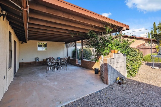 view of patio / terrace featuring outdoor dining area, a trampoline, and fence