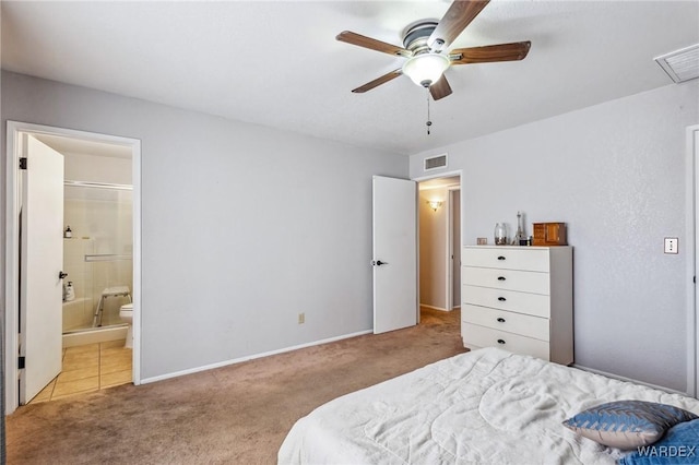 bedroom with light carpet, baseboards, visible vents, and ensuite bathroom