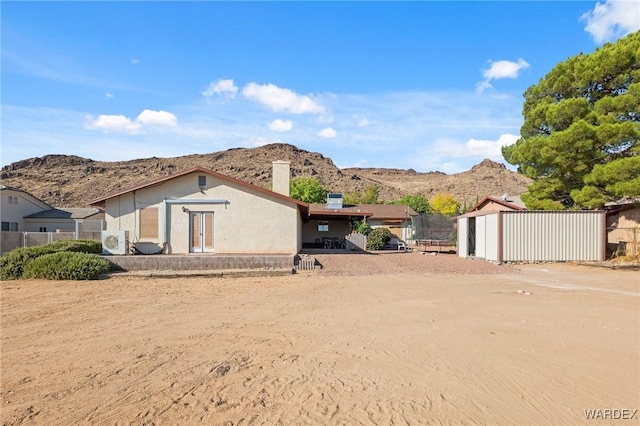 view of front of house featuring ac unit, a mountain view, and fence