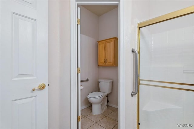 full bath with baseboards, tile patterned flooring, toilet, and a shower stall