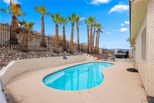 view of pool with a hot tub, a patio area, a fenced backyard, and a fenced in pool