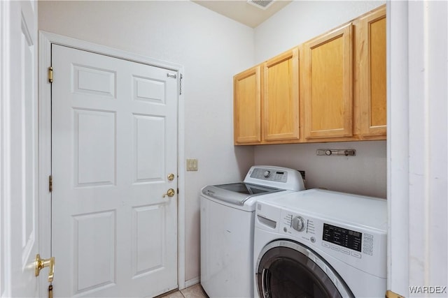 laundry area with visible vents, washer and clothes dryer, and cabinet space