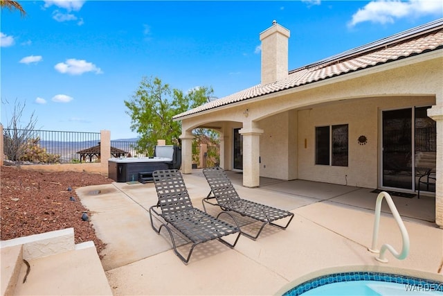 view of patio with fence and a hot tub