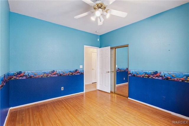 empty room featuring ceiling fan, wood finished floors, and baseboards