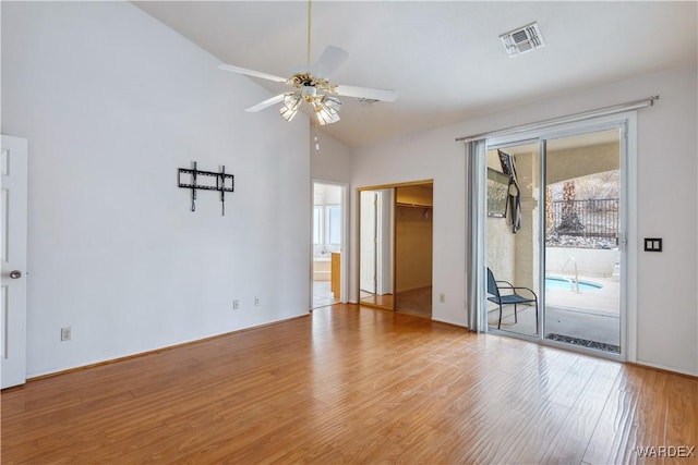 unfurnished room featuring high vaulted ceiling, a ceiling fan, visible vents, and wood finished floors