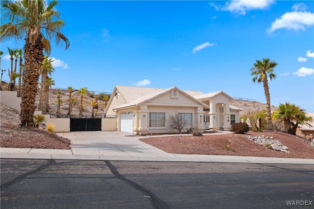 view of front facade with driveway, a garage, fence, and stucco siding