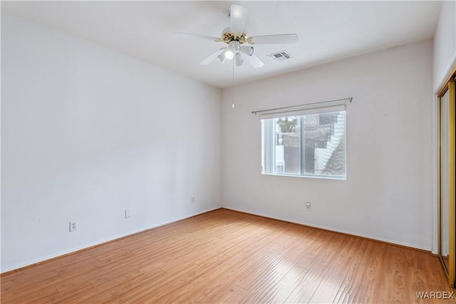 unfurnished room with light wood-style flooring, visible vents, and ceiling fan