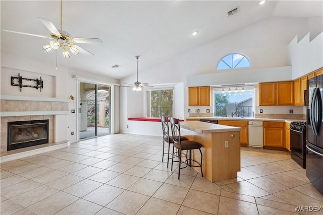 kitchen featuring open floor plan, light countertops, a kitchen island, and a kitchen bar