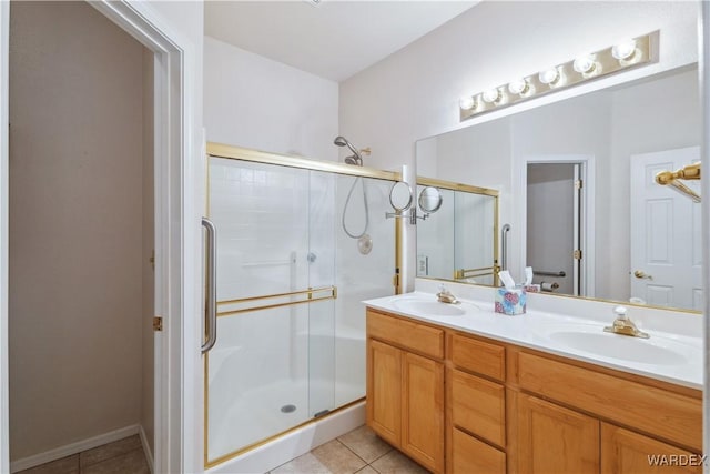 bathroom featuring a stall shower, tile patterned flooring, and a sink