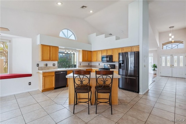 kitchen featuring light countertops, a sink, black appliances, and light tile patterned floors