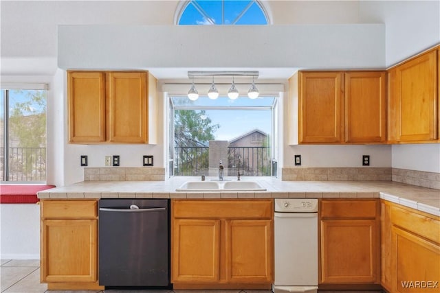 kitchen featuring tile counters, a sink, and dishwasher