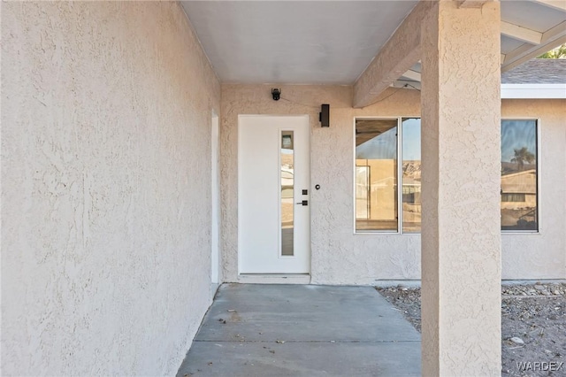 doorway to property with a patio area and stucco siding