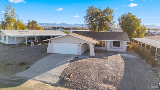 single story home featuring a mountain view, driveway, an attached garage, and stucco siding