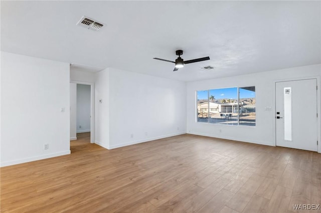 unfurnished room with a ceiling fan, light wood-type flooring, visible vents, and baseboards