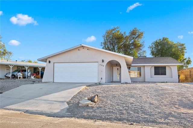 ranch-style house featuring driveway, an attached garage, and stucco siding