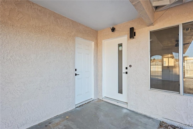 doorway to property with a patio area and stucco siding