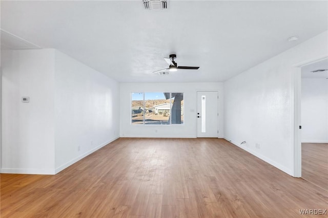 unfurnished living room with a ceiling fan, visible vents, light wood-style flooring, and baseboards