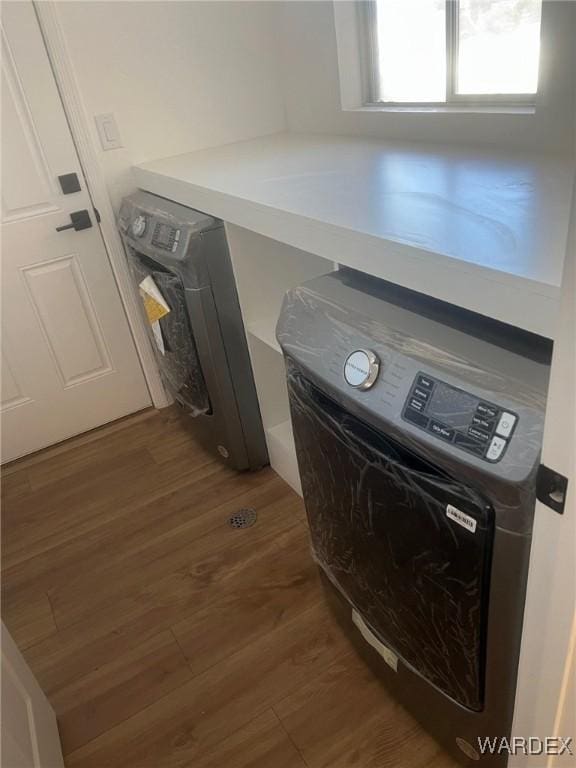 laundry area with dark wood finished floors and washer / dryer