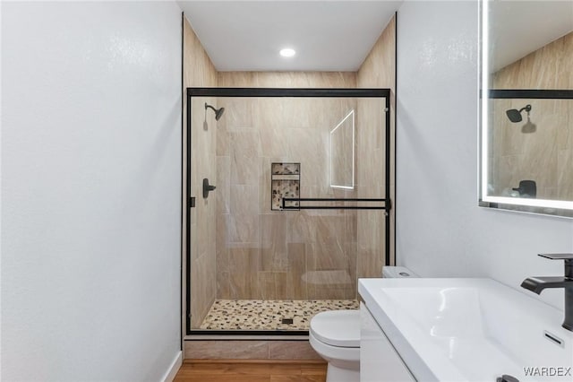 full bathroom featuring vanity, wood finished floors, a shower stall, and toilet