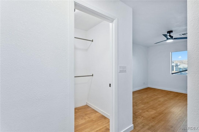 spacious closet with ceiling fan, visible vents, and wood finished floors